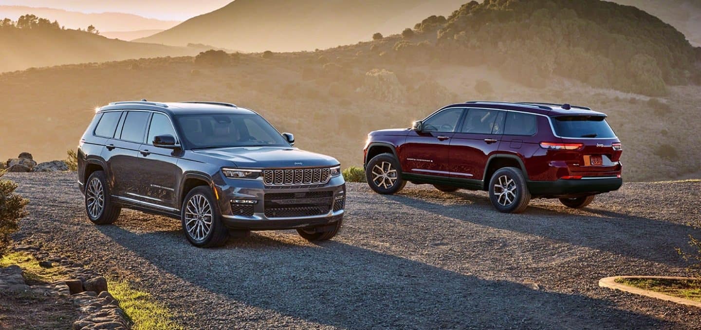 Two Jeep Grand Cherokee 4xe SUVs parked on a mountain.